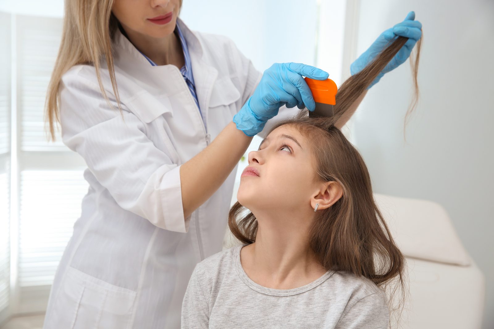 Lice Lifters of Greater Washington technician using nit comb on girl's hair during professional lice treatment