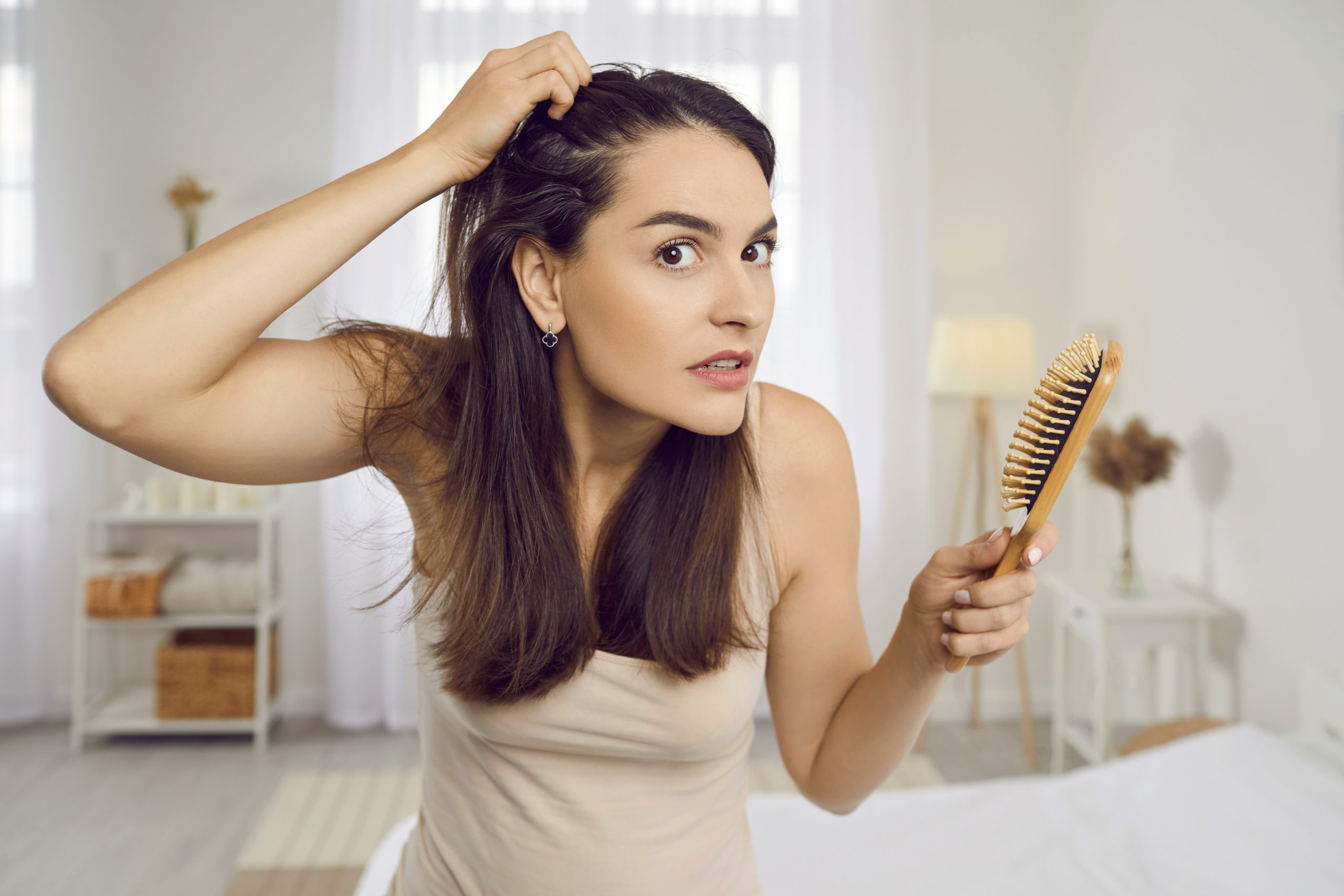 Adult woman checking her hair in a mirror for head lice