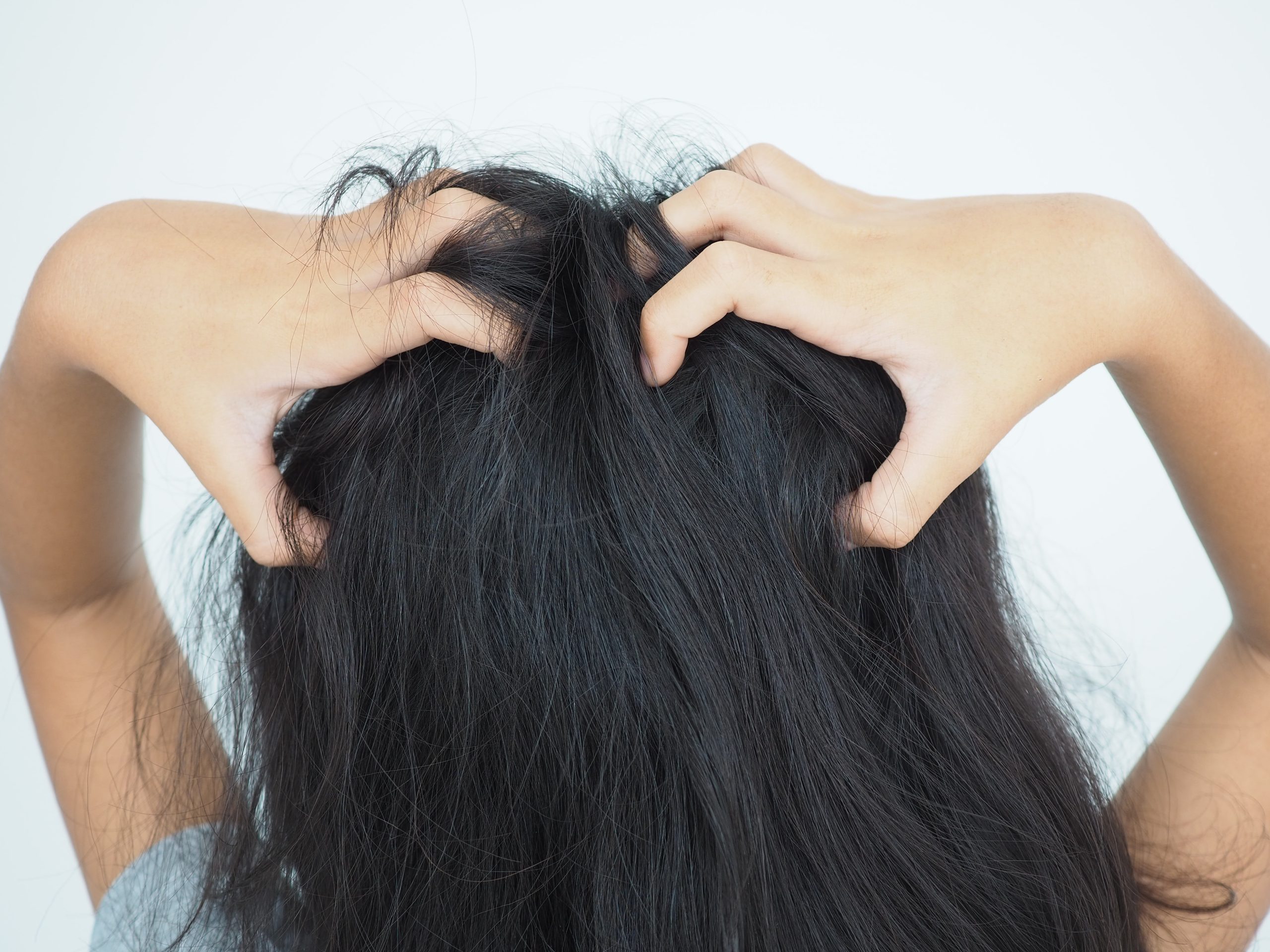 Child scratching an itchy scalp as a possible sign of head lice
