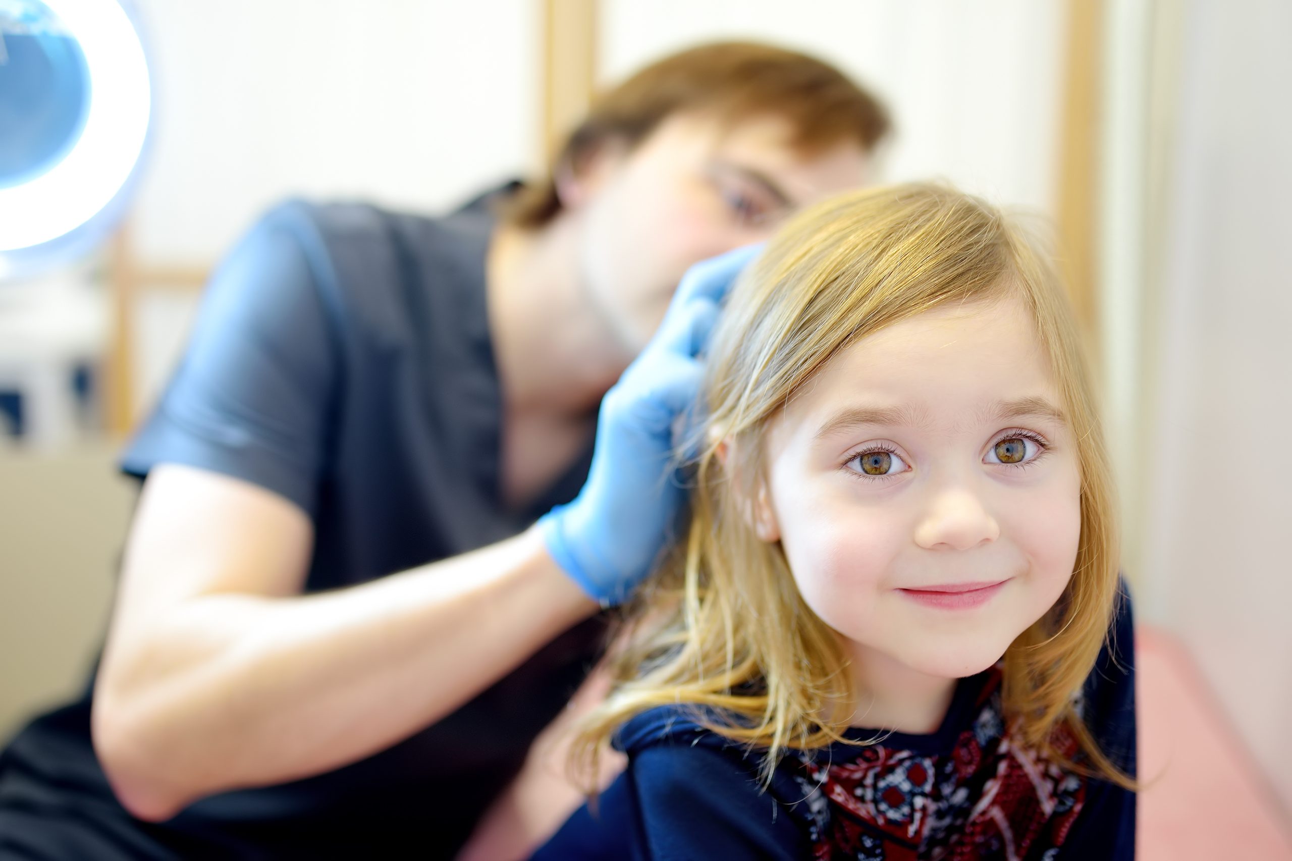 Clinician examining a child's hair and scalp for lice and nits