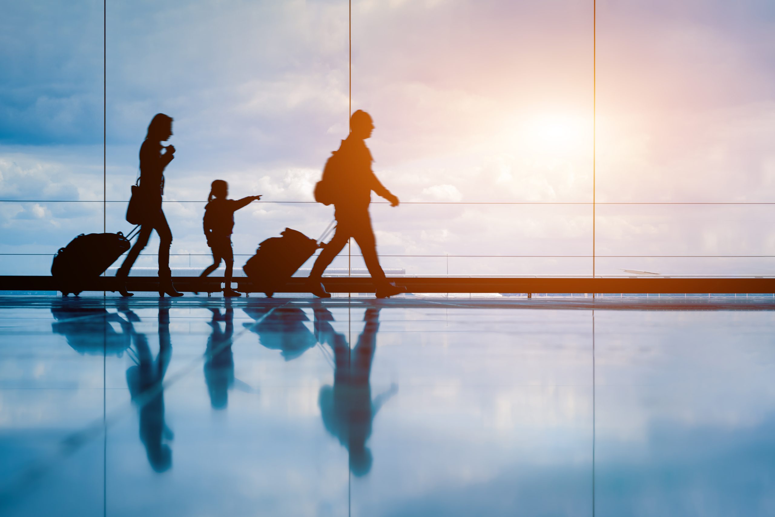 Family traveling through an airport with luggage