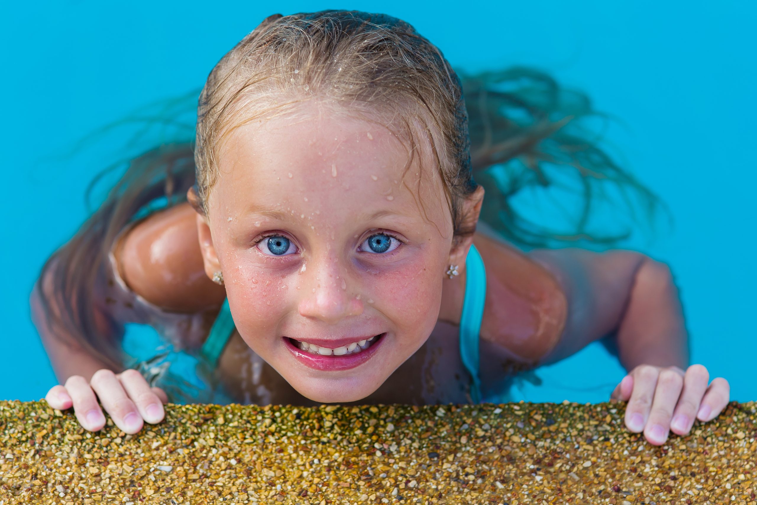 Child swimming in a pool for a lice and pool safety article